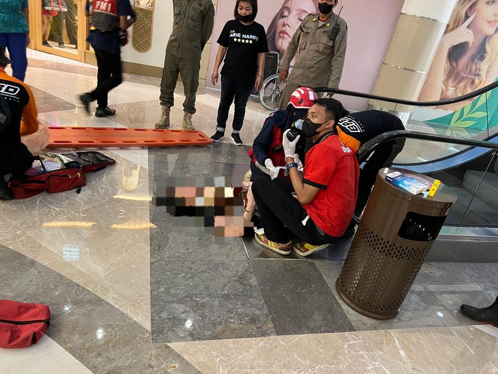 Wanita Tergeletak dekat eskalator